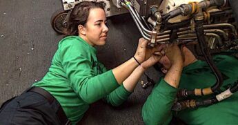 Aviation Machinist Mate 3rd Class Kaley Coustaut, left, from Orange County, California, and Aviation Machinist Mate 3rd Class Austin Mollard, from New Taipei, Taiwan, install a new wiring harness to an Air Refuling Store in the Hangar Bay of the Nimitz-class aircraft carrier USS Harry S. Truman, Dec. 6, 2021. (U.S. Navy photo by Mass Communication Specialist Seaman Hunter Day)
